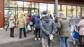 Kunden eines Aldi-Supermarktes gehen durch die Eingangstür. (Quelle:dpa/Fabian Sommer)