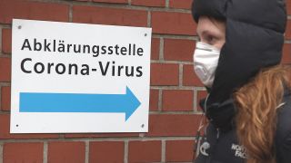 Symbolbild: Eine junge Frau kommt mit Schutzmaske von der Abklärungsstelle Coronavirus im Vivantes Wenckebach-Klinikum im Bezirk Tempelhof. (Quelle: dpa/W. Kumm)