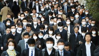 Symbolbild: Passanten in Tokio tragen Schutzmasken und gehen dicht aneinander gedrängt über eine Straße. (Quelle: dpa/Kyodo)