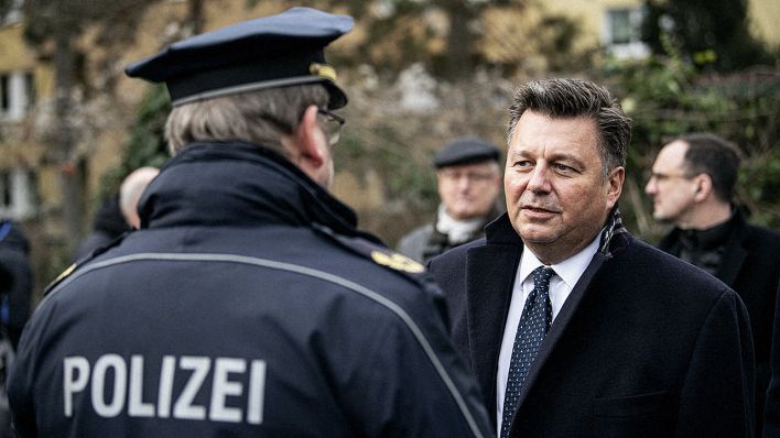 Andreas Geisel (SPD, l), Innensenator, spricht in Berlin Neukölln mit einem Polizisten. (Quelle: dpa/Sommer)