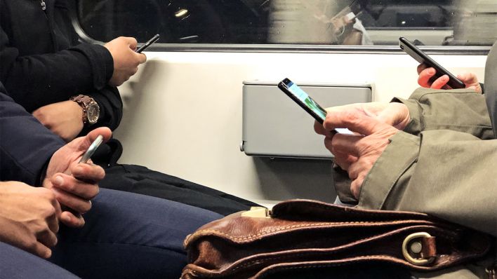Mehrere Menschen sitzen in einer S-.Bahn und benutzen ihr Handy (Bild: dpa/Reinhard Kungel)