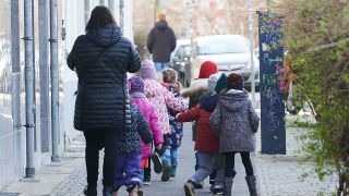 Einige Kinder gehen mit einer Aufsichtsperson in Berlin auf dem Gehweg (Quelle: dpa/Riedl).