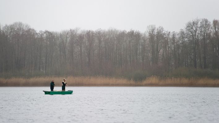 Zwei Männer stehen am 11.12.2013 in einem Ruderboot auf dem Groß Schauener See in Groß Schauen bei Storkow. (Quelle: dpa/Patrick Pleul)