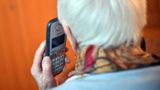 Symbolbild: Eine Seniorin hält einen Telefonhörer an ihr Ohr (Quelle: dpa/Britta Pedersen)