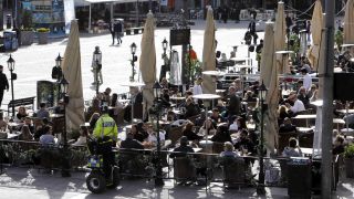 Die Menschen in Stockholm auf einem Marktplatz, sitzen und bewegen sich frei. (Quelle: dpa)