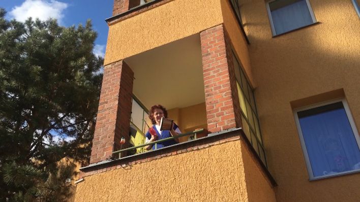 Eine Frau schlägt auf einem Balkon auf einen Topf (Foto: Grit Lieder/rbb24)
