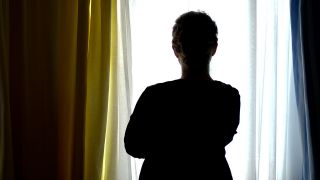 Archivbild: Eine junge Frau steht am 28.08.2013 in einem Zimmer eines Frauenhauses. (Quelle: dpa/Peter Steffen)