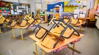 Symbolbild - Stühle stehen in einer Grundschule nach Ende der letzten Unterrichtsstunde aufgrund von Corona auf den Tischen. (Bild: dpa/Sebastian Gollnow)