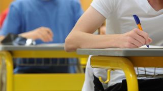 Abiturienten eines Gymnasiums schreiben in einer Turnhalle die Abiturprüfung in Deutsch. (Quelle: dpa/Armin Weigel)