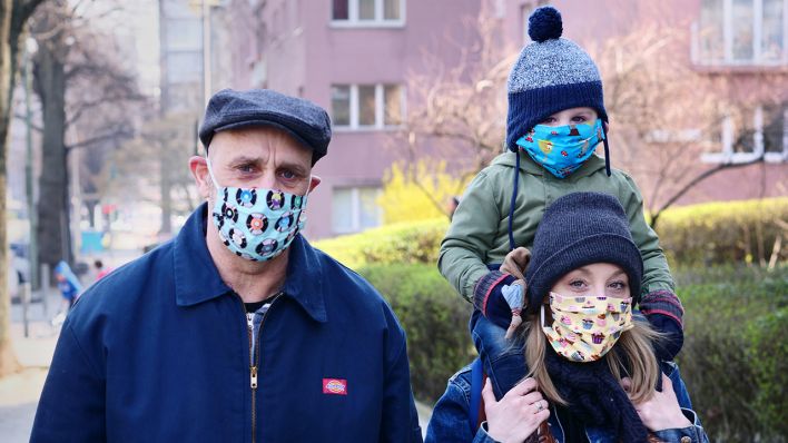 Eine Familie geht in Friedenau spazieren. Alle Familienmitglieder tragen dabei bunte Masken, als Schutz gegen das Coronavirus. Die Masken wurden von einer Freundin der Familie selbst genäht. (Bild: dpa/Wolfram Steinberg)