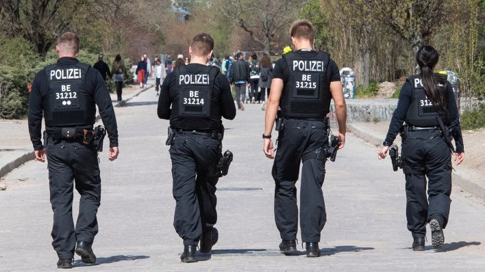 10.04.2020, Berlin: Polizisten gehen durch den Mauerpark und schauen, ob die Kontaktbeschränkungen eingehalten werden (Quelle: dpa/Christophe Gateau)