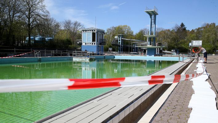 Das Schwimmbecken des Sommerbads Neukölln ist am 17.04.2020 mit einem Flatterband abgesperrt. (Bild: dpa/Andreas Gora)