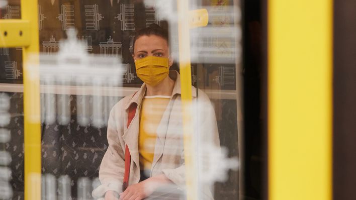 Eine Frau sitzt am 27.04.2020 in der Berliner U-Bahn und trägt einen Mund-Nasen-Schutz. (Bild: dpa/Annette Riedl)