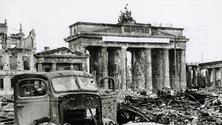 Das stark beschädigte Brandenburger Tor auf dem von Trümmern bedeckten Pariser Platz zum Kriegsende 1945 (Bild: dpa/akg)