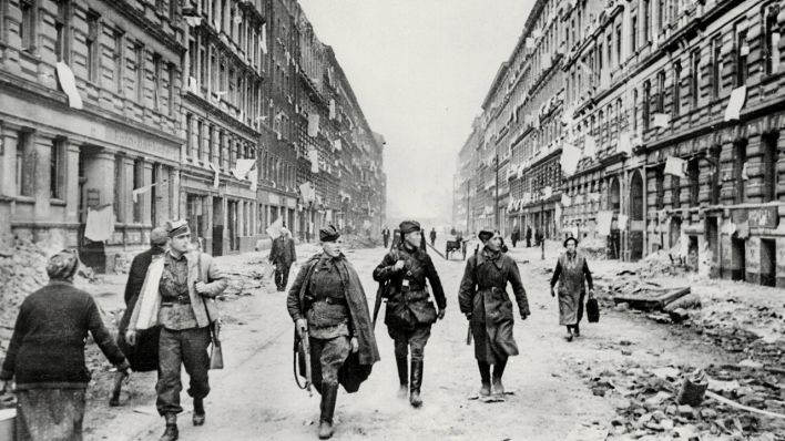 Sowjetische Soldaten laufen durch das zerstörte Berlin 194 (Bild: dpa/akg)