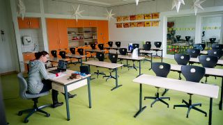Eine Lehrerin sitzt in ihrem leeren Klassenzimmer vor einem Laptop. (Quelle: dpa/Kay Nietfeld)