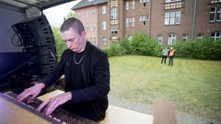 Cameron Carpenter, Organist, spielt auf einer auf einem Lkw montierten elektronischen Orgel vor einem Seniorenheim in Berlin-Spandau. (Quelle: dpa/Christoph Soeder)