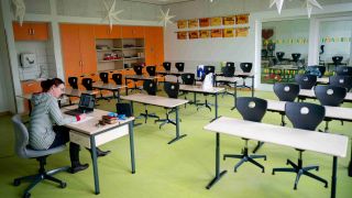 Symbolbild: Karin Bitter, Lehrerin an einer brandenburger Schule, sitzt in ihrem leeren Klassenzimmer vor einem Laptop. (Quelle: dpa)