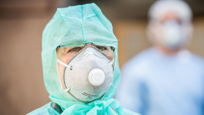 Eine Ärztin mit Atemschutzmaske steht im Hinterhof einer Arztpraxis in Kreuzberg (Quelle: dpa/Michael Kappeler)