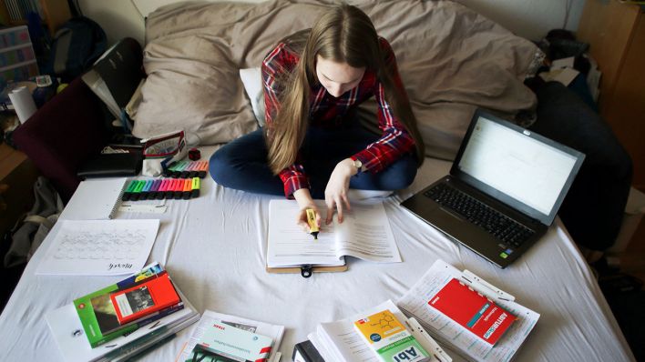 Symbolbild: Eine Schülerin lernt zuhause für das Abitur. (Quelle: dpa/David Young)