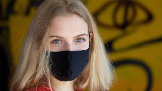 Eine Frau mit einer selbstgenähten Schutzmaske (Bild: imago images/Marcel Lorenz)