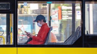 Ein Fahrgast in einem Bus der Berliner Verkehrsbetriebe (BVG) mit Gesichtsmaske. Quelle: Stefan Zeitz/www.imago-images.de