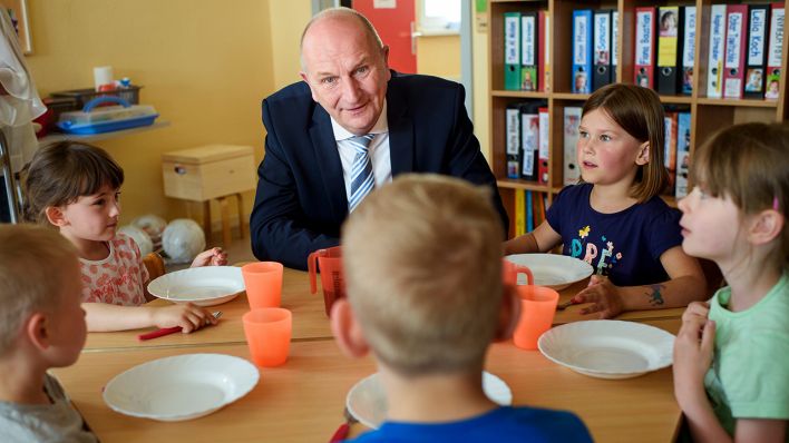 Archivbild: Dietmar Woidke (SPD), Ministerpräsident von Brandenburg, unterhält sich am 24.05.2019 während eines Besuches der Kindertagesstätte Rappelkiste in Teltow mit Kindern. (Quelle: dpa/Gregor Fischer)