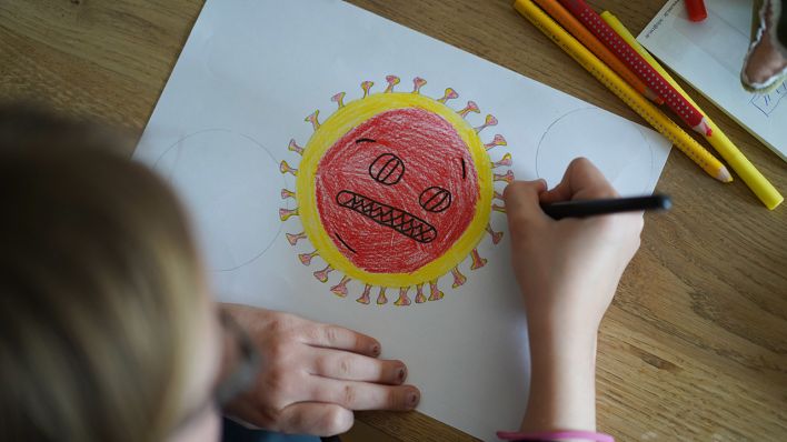 Symbolbild - Ein Kind malt einen Coronavirus (Bild: dpa/Jörg Carstensen)