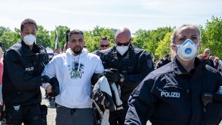 Attila Hildmann wird am 09.05.2020 bei einer Demonstration vor dem Reichstagsgebäude von Polizisten abgeführt. (Quelle: dpa/Christophe Gateau)