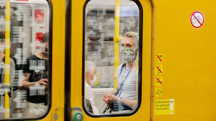 Eine Frau mit Mundschutz ist im U-Bahnhof Turmstraße in einer U-Bahn zu sehen. (Quelle: dpa/Christoph Soeder)