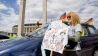 Eine Frau steht bei einer Kundgebung gegen die Corona-Politik der Bundesregierung mit einem Plakat am Olympiastadion. (Quelle: dpa/C. Soeder)