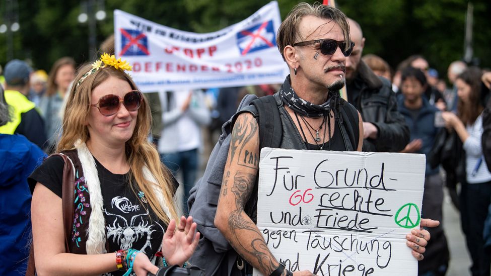 Teilnehmer einer Demonstration gegen die Stationierung von US-Atomwaffen in Ramstein protestieren u.a. mit einem Schild "Für Grundrechte und Friede - gegen Täuschung und Kriege" am Brandenburger Tor. (Quelle: dpa/B. Jutrczenka)