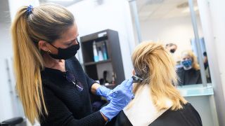 Eine Friseurin färbt in einem Friseursalon einer Kundin die Haare. (Quelle: dpa/Sebastian Gollnow)