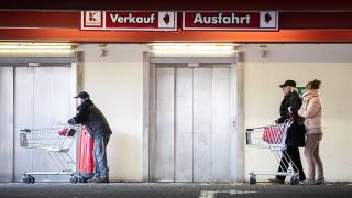 Menschen stehen mit Einkaufswagen vor einem Supermarkt und warten auf den Einlass (Bild: imago images/Florian Gaertner)