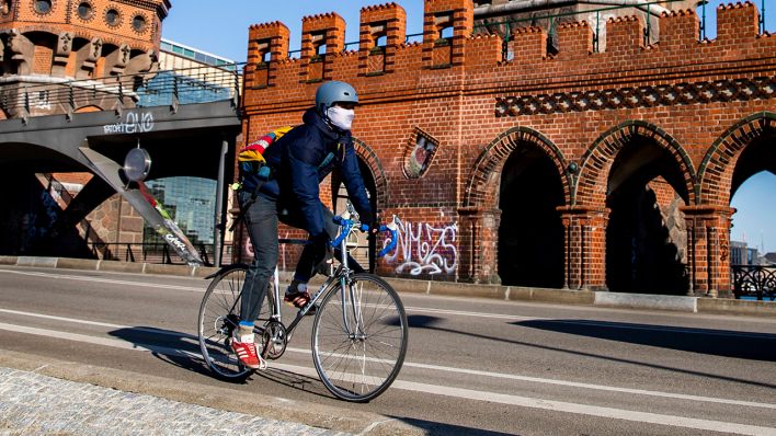 Ein Radfahrer mit Mundschutz faehrt auf dem Oberbaumbruecke in Berlin am 23. Maerz 2020. (Quelle: imago images/Emmanuele Contini)