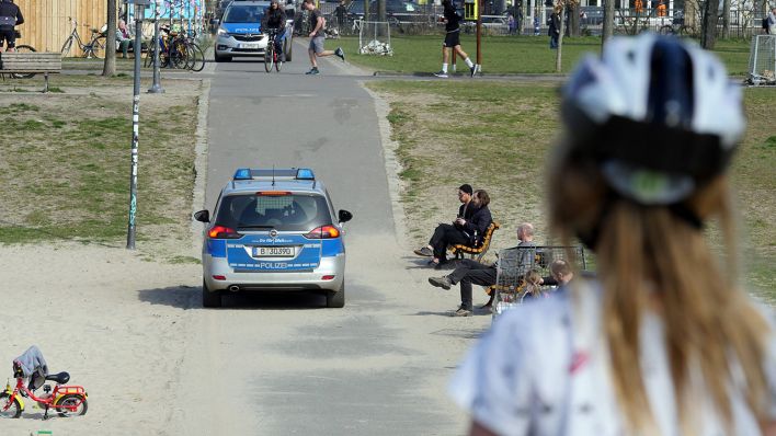 Menschen halten am 27.03.2020 sich im Volkspark Friedrichshain auf, während die Polizei die Einhaltung der Abstandsregeln kontrolliert (Bild: imago-images/Sabine Gudath)