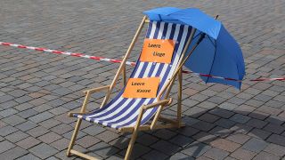 "Leere Liege - leere Kasse" steht auf einem Strandstuhl während einer Demonstration für Staatshilfen für die Reisebranche aufgrund der Corona-Pandemie in Potsdam am 29.04.2020 (Bild: imago-images/Martin Müller)