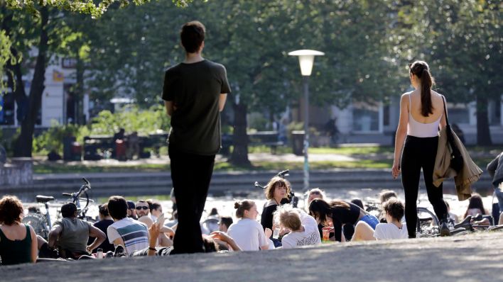 Menschen sitzen am 8. Mai im Volkspark am Weinberg in Berlin-Mitte. (Quelle: imago/