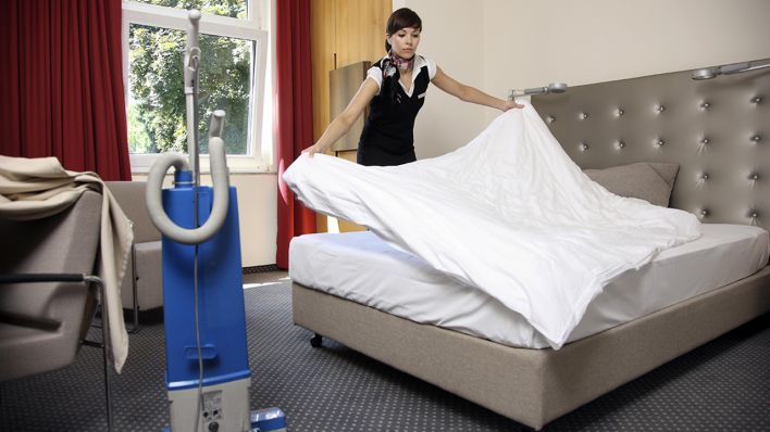 Symbolbild - Eine Hotelfachfrau arbeitet im Zimmerservice (Bild: dpa/Jochen Tack)