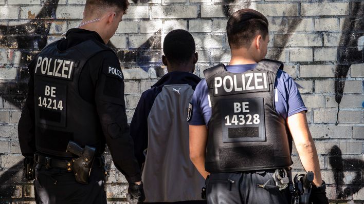 Polizeibeamte kontrollieren im Görlitzer Park einen mutmaßlichen Drogendealer