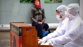 Archiv - Zwei Musiker spielen am 12.05.2020 in der Potsdamer Innenstadt in weißen Overalls und mit Mundschutz und Handschuhen Piano, um für Soforthilfen für Künstler zu demonstrieren. (Bild: dpa/Sören Stache)