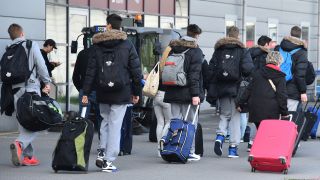 Mit Rollkoffern verlassen Passagiere in Schönefeld (Brandenburg) das Flughafengebäude. (Quelle: dpa/Bernd Settnik)