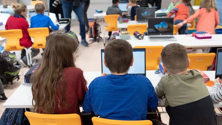 Schüler einer 3. Klasse sitzen während eines Presserundgangs in einem Klassenzimmer der Grundschule Georgius Agricola vor einem Laptop. (Quelle: dpa/Sebastian Kahnert)