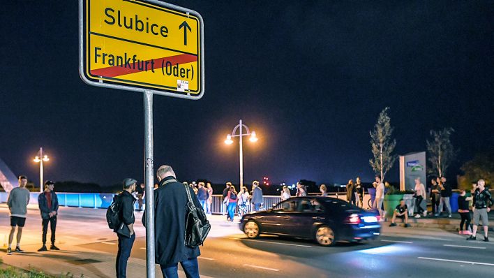 13.06.2020, Polen, Slubice: Passanten stehen vor der Stadtbrücke zwischen dem polnischen Slubice und Frankfurt (Oder) in Deutschland und warten auf die Grenzöffnung. (Quelle: dpa/Pleul)