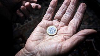 ILLUSTRATION - Eine 83-jährige Frau hält eine Euromünze. (Quelle: dpa/Karl-Josef Hildenbrand)