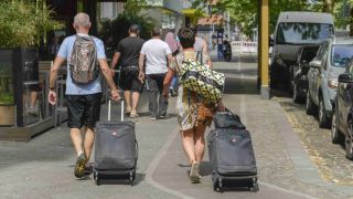Symbolbild: Touristen mit Rollkoffern laufen in Berlin Mitte auf dem Gehweg. (Quelle: dpa/Schoening)