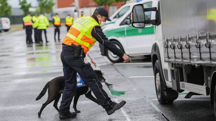 Symbolbild: Ein Zollbeamter untersucht mit Zollhund einen Transporter nach meldepflichtigen Substanzen. (Quelle: dpa/A. Arnold)