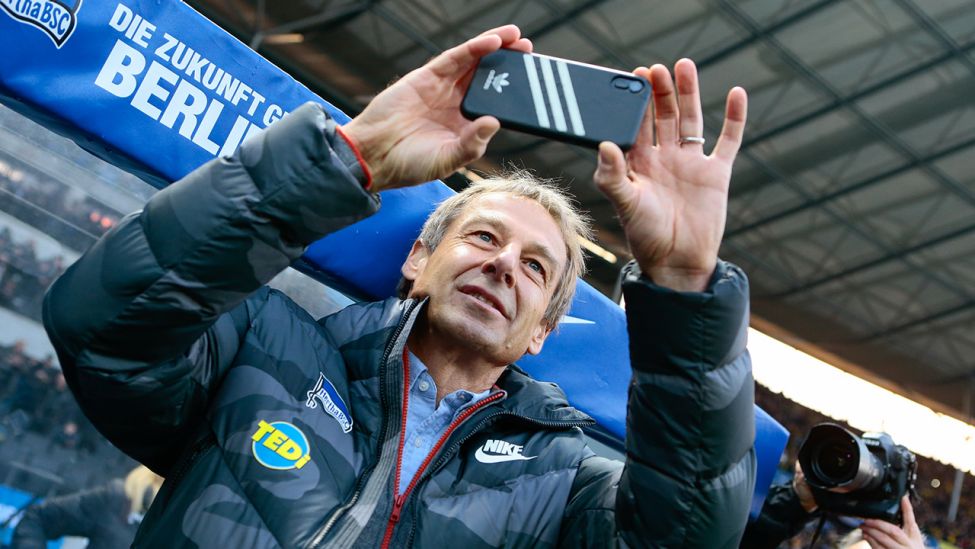 Jürgen Klinsmann filmt mit seinem Handy das Olympiastadion (Quelle:imago/Jan Huebner)