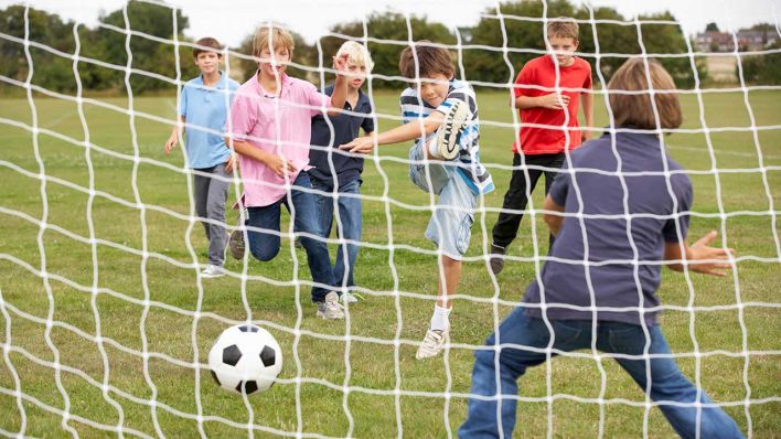 Kinder spielen Fußball (Bild: imago images/Monkey Business)