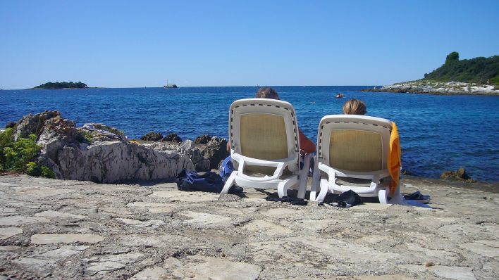 Urlaub in Zeiten der Coronavirus Pandemie: Zwei Urlauber sonnen sich auf Liegestühlen am adriatischen Meer. Quelle: Sven Simon/dpa